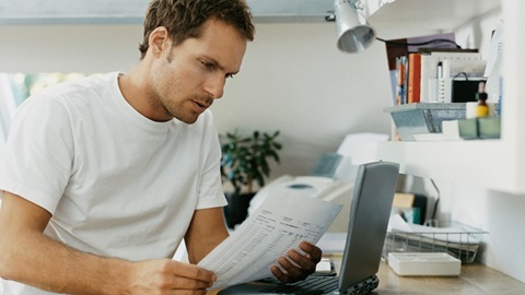 homem a olhar para a fatura da luz